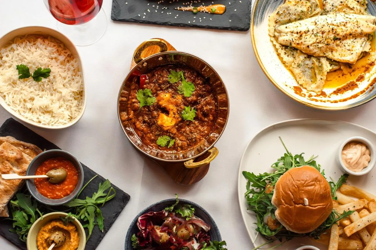 a table with plates of food and bowls of food at Domo Boutique Hotel Birmingham in Birmingham