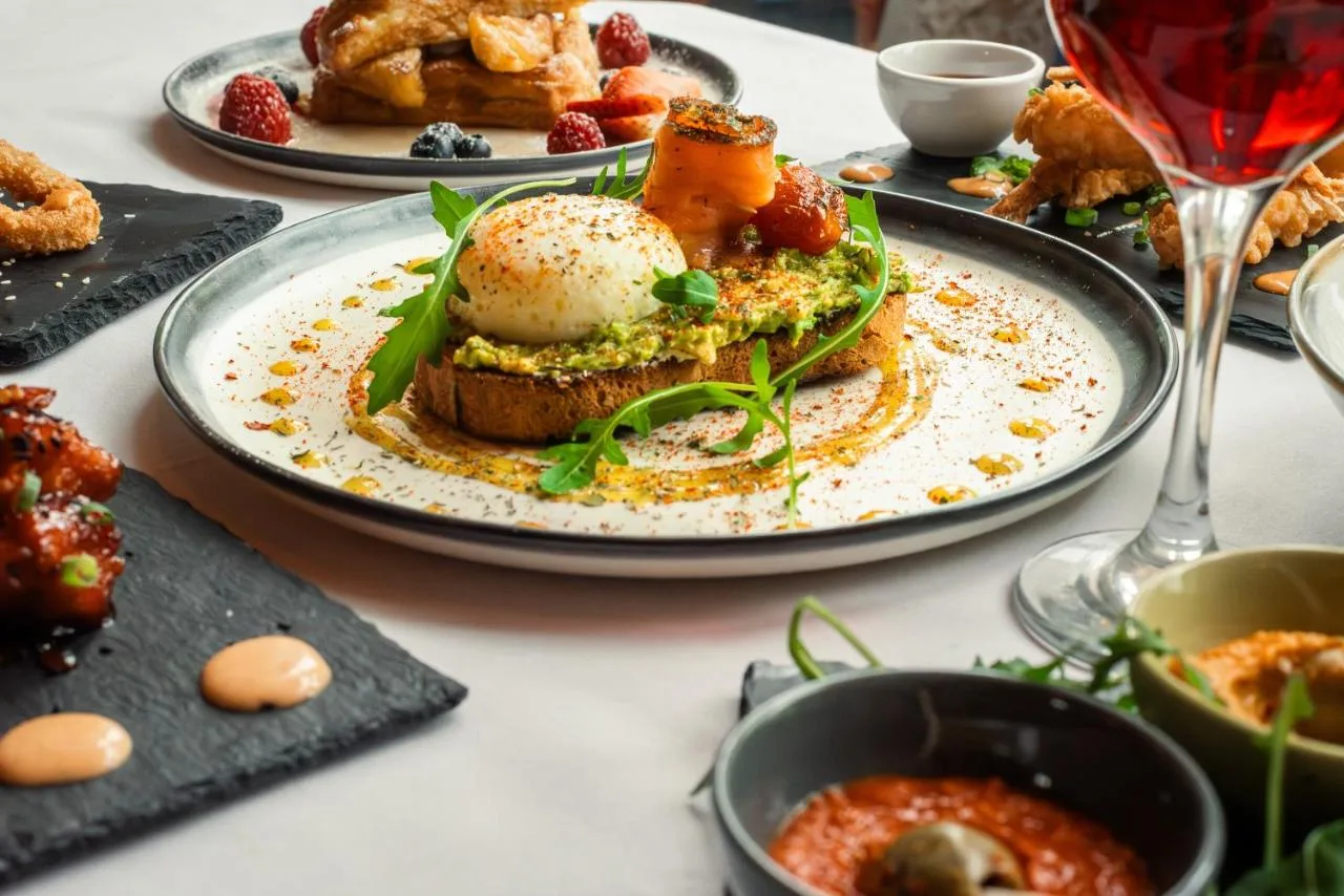 a table with a plate of food on a table at Domo Boutique Hotel Birmingham in Birmingham